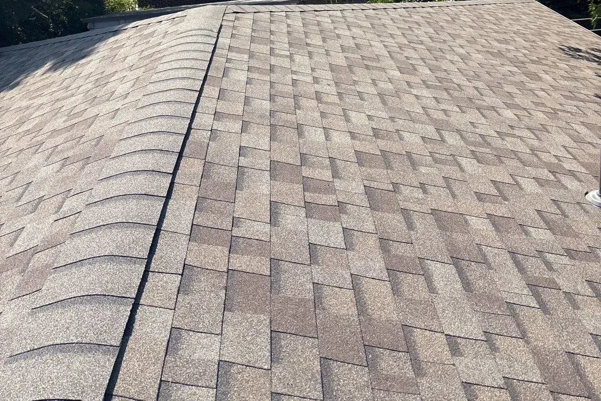 Finished light brown blend architectural shingles running up to a capped ridge
