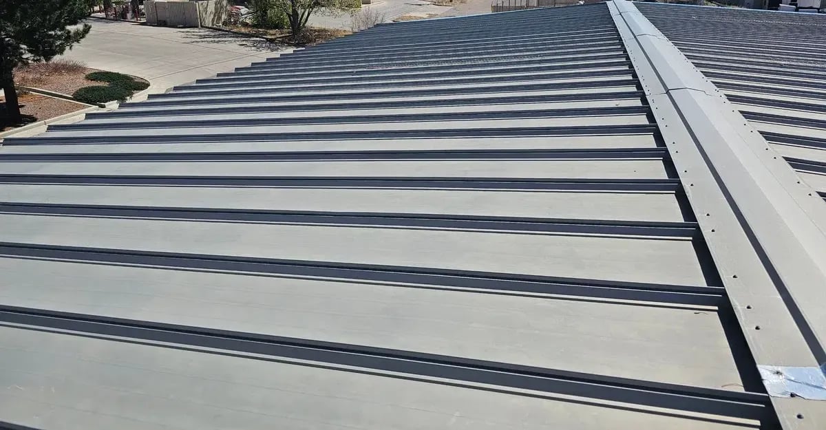 Gray standing seam metal roof with a ridge cap on a commercial building