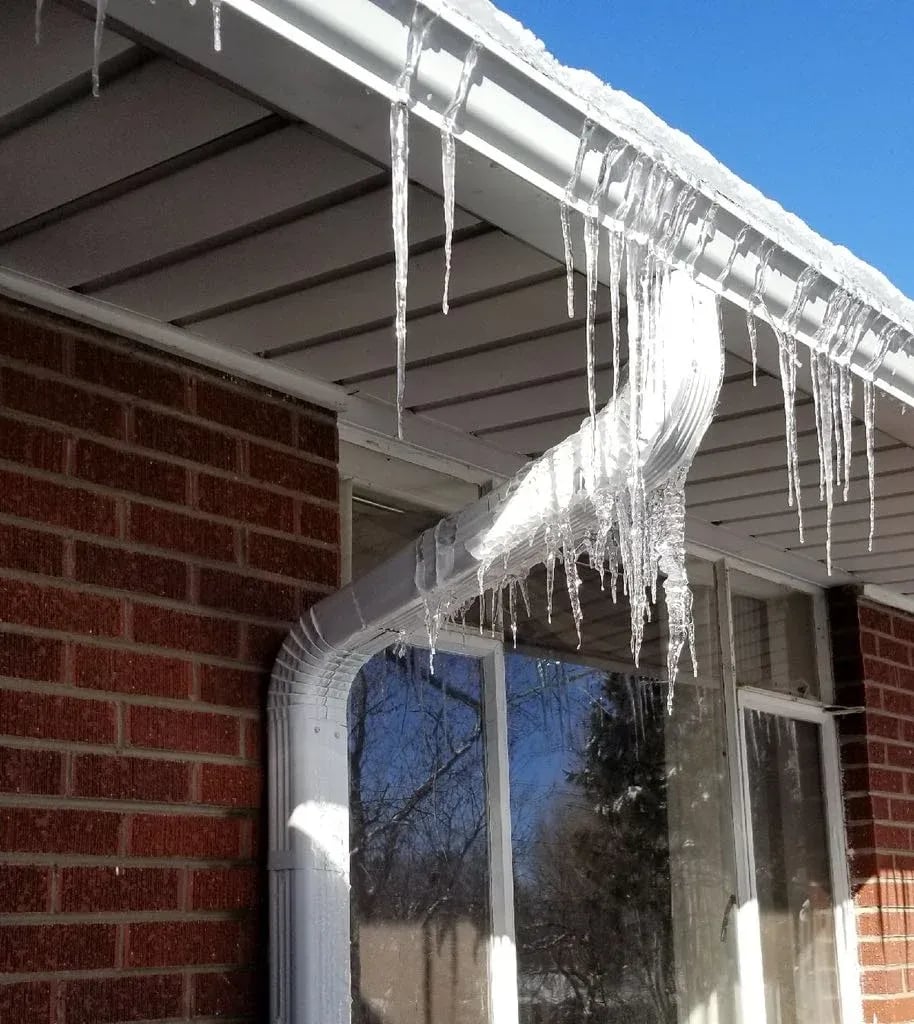 Icicles and ice built up along a gutter and downspout