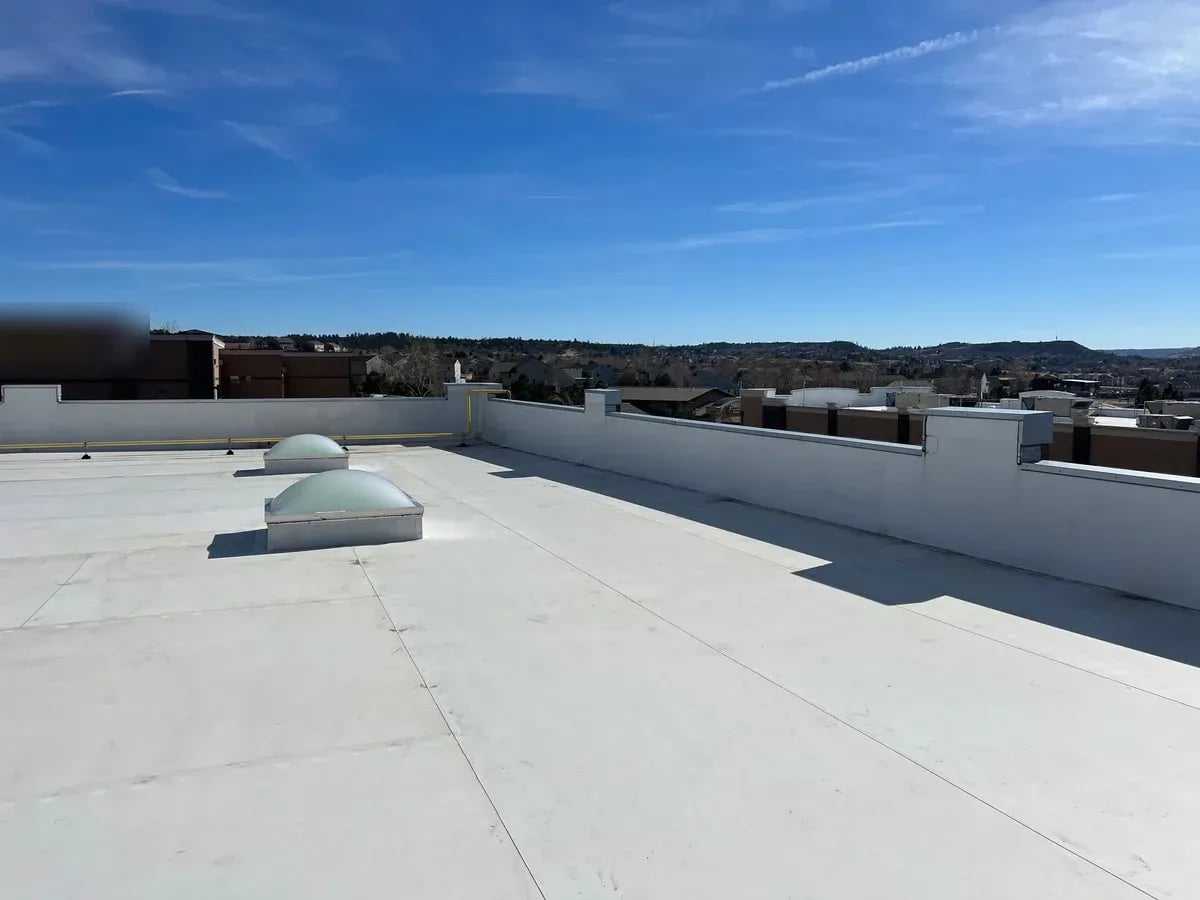 New white TPO flat roof with two domed skylights