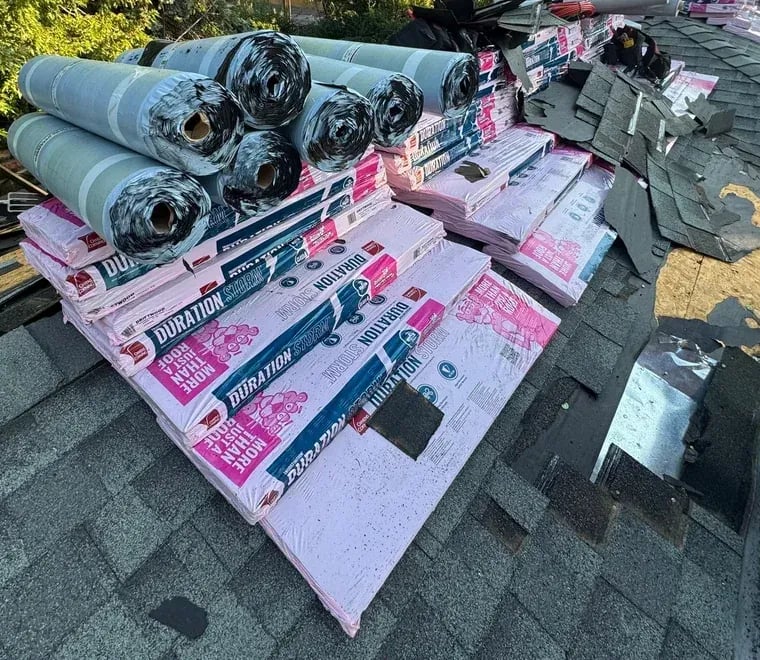 Owens Corning Duration bundles and underlayment rolls loaded on a roof during a tear-off