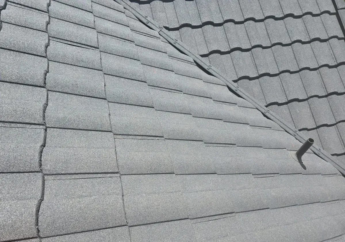 Close view of the granular stone coating and overlapping profile of steel roof panels